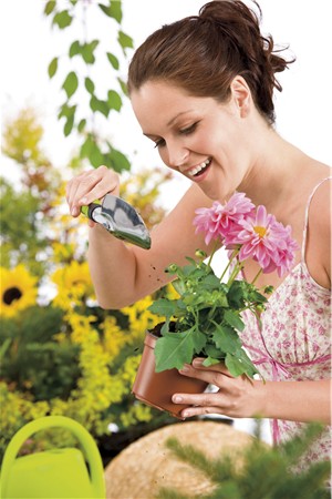 Gardening - woman holding flower pot and shovel